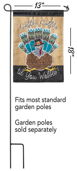 Decorative garden flag with a turkey design and text on a burlap background.