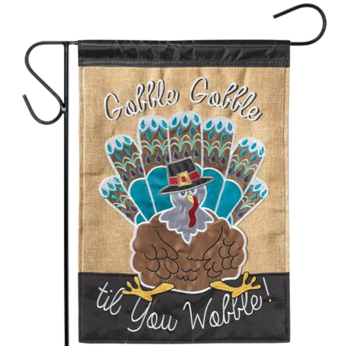 Decorative garden flag with a turkey design and text on a burlap background.