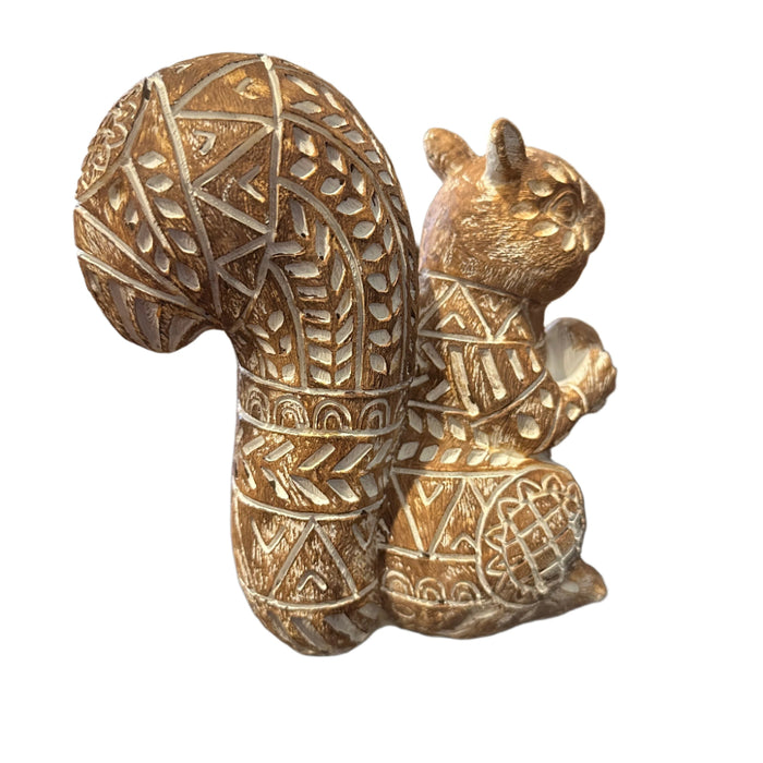 Decorative squirrel figurine with intricate floral-like patterns on a white background