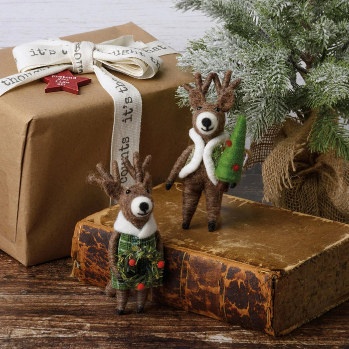 Two decorative felted reindeer figures with festive outfits on