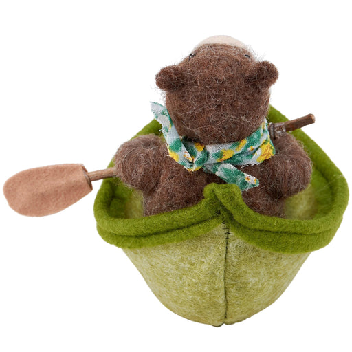 felted bear in a green boat with a paddle on a white background