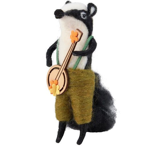 Felted skunk playing a banjo figurine that stands on a table