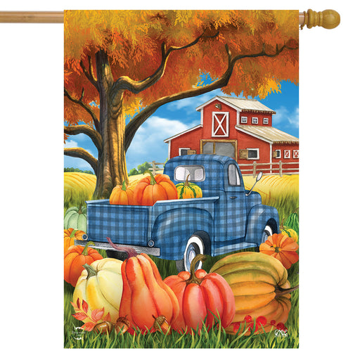 Decorative flag with a blue truck, pumpkins, and barn scene on an autumn background.