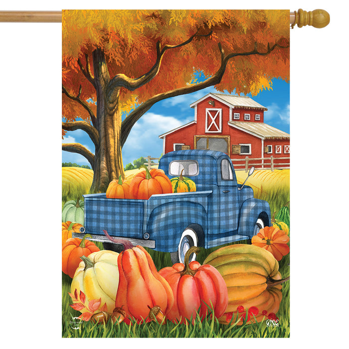 Decorative flag with a blue truck, pumpkins, and barn scene on an autumn background.