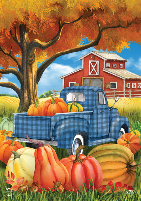 Decorative flag with a blue truck, pumpkins, and barn scene on an autumn background.