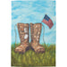 Garden flag with boots and American flag against a blue sky and grass background