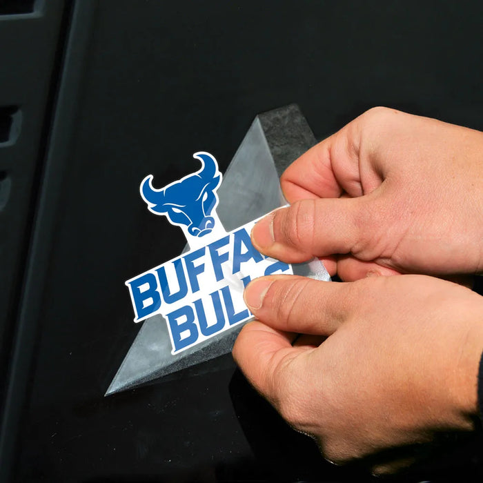 Person applying a 'Buffalo Bulls' decal to a black surface