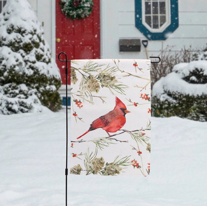 Garden flag with a red cardinal bird on a branch design, featuring winter elements like pinecones and berries.