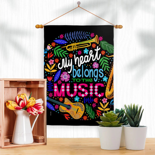 Decorative flag with musical instruments and colorful text on a black background