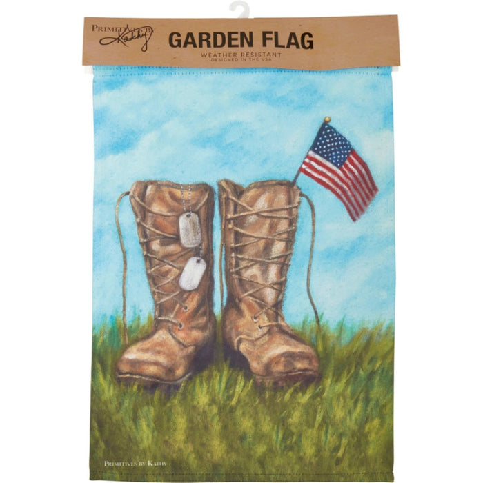 Garden flag with boots and American flag against a blue sky and grass background