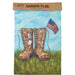 Garden flag with boots and American flag against a blue sky and grass background