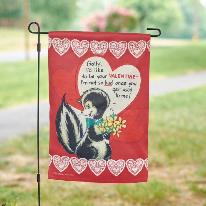 Valentine's Day-themed garden flag with cartoon skunk holding flowers and text on a red background with heart designs.