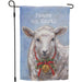 Decorative garden flag with a sheep wearing a Christmas wreath and bell, featuring the text 'Peace on Earth'.