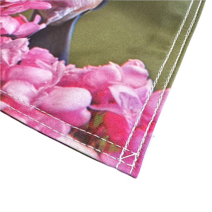 Garden flag with a bluebird and pink flowers on a green background