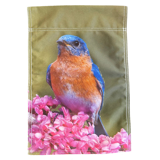 Garden flag with a bluebird and pink flowers on a green background