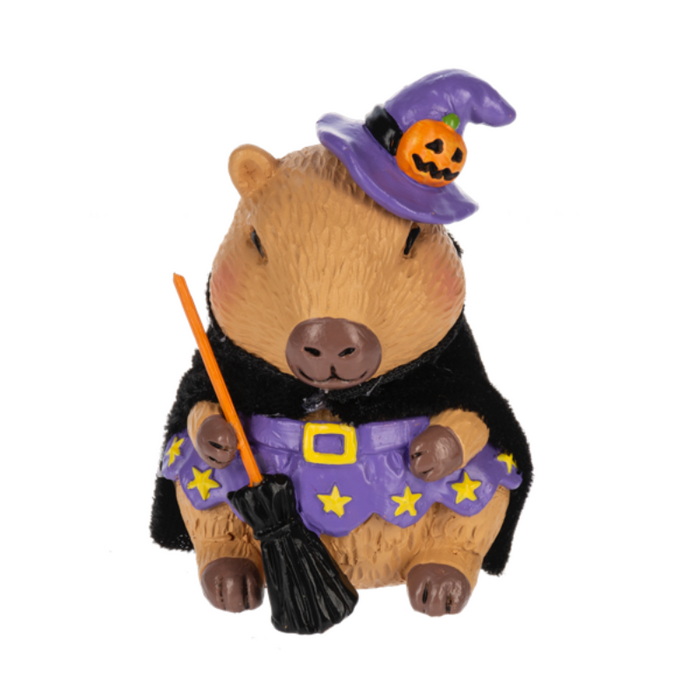 Halloween-themed capybara figurine wearing a witch costume with a broom and purple hat on a white background