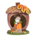 Decorative figurine of a mouse in an acorn house with autumn leaves and sweeping with a broom