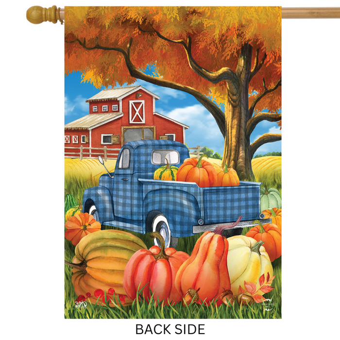 Decorative flag with a blue truck, pumpkins, and barn scene on an autumn background.