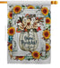Decorative flag with 'Give Thanks!' text in a pumpkin vase surrounded by flowers and sunflowers.