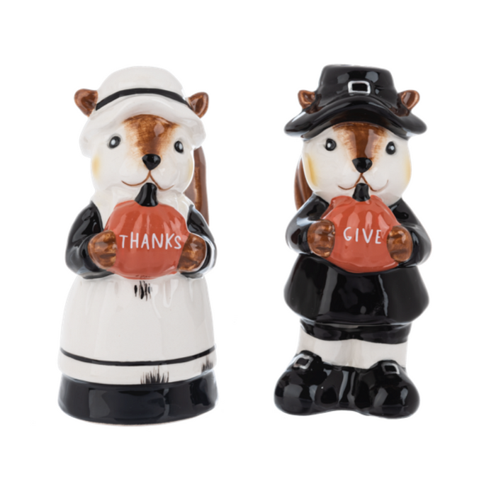 Two ceramic squirrel salt and pepper shakers, one in a pilgrim outfit and the other in a maid outfit, holding pumpkins that say "Give" "Thanks".
