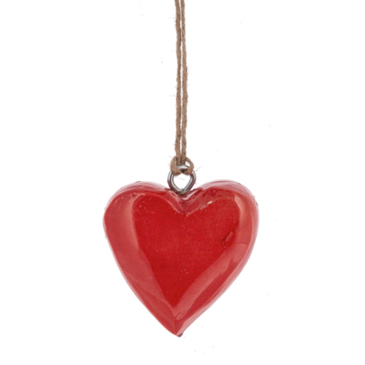 Red heart-shaped ornament hanging on a string against a white background