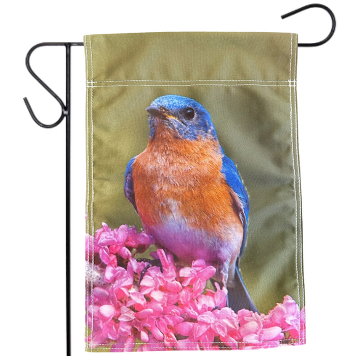 Garden flag with a bluebird and pink flowers on a green background