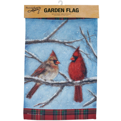 Garden flag with two cardinals on a branch against a blue sky background and snow