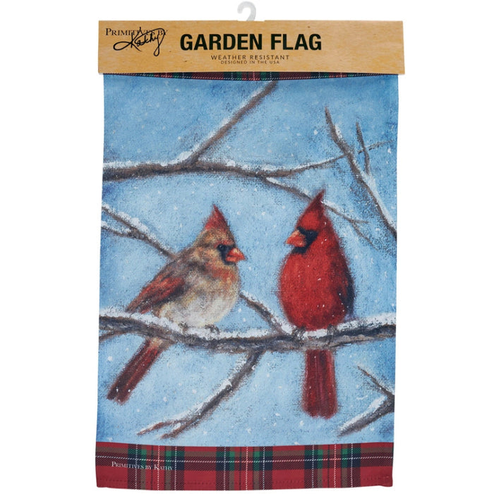 Garden flag with two cardinals on a branch against a blue sky background and snow