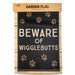 Garden flag with 'Beware of Wigglebutts' text and paw prints on a wooden looking background