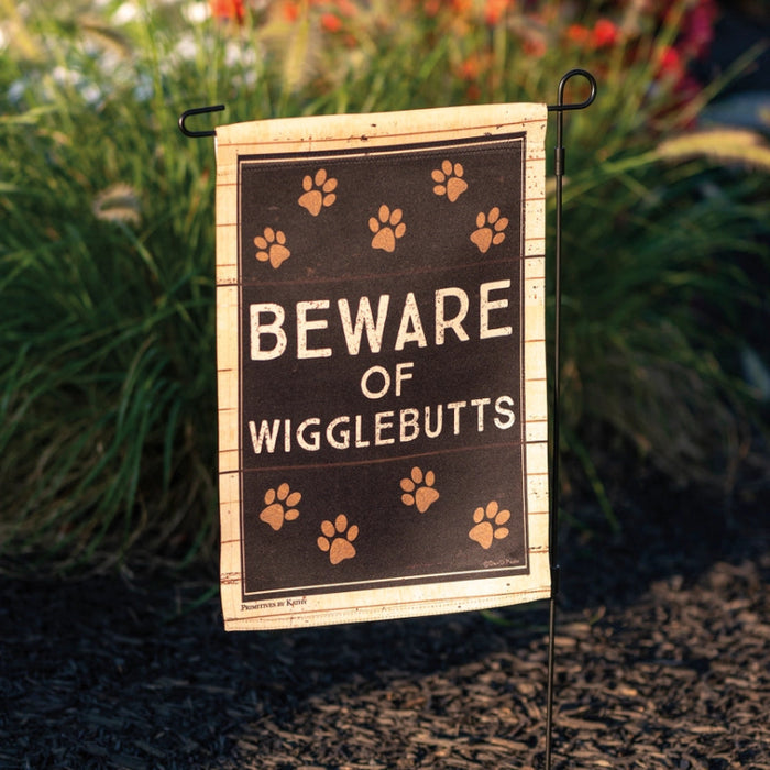 Garden flag with 'Beware of Wigglebutts' text and paw prints on a wooden looking background