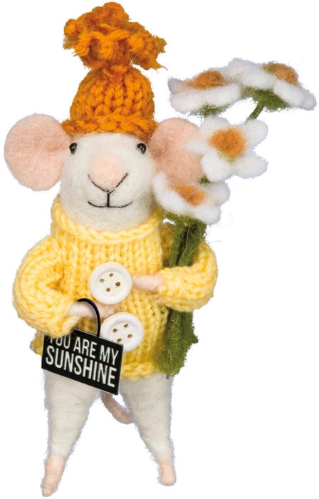 Stuffed mouse toy wearing a yellow sweater and hat, holding flowers and holding a sign