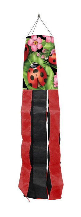 windsock with a ladybug and flowers design on top with red and black tails