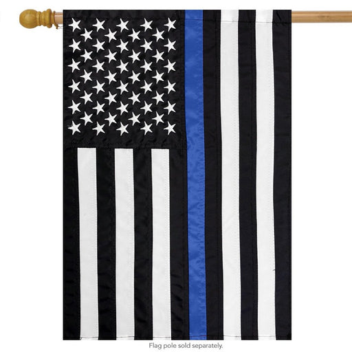 black and white american flag with a single blue stripe down the center on a flagpole