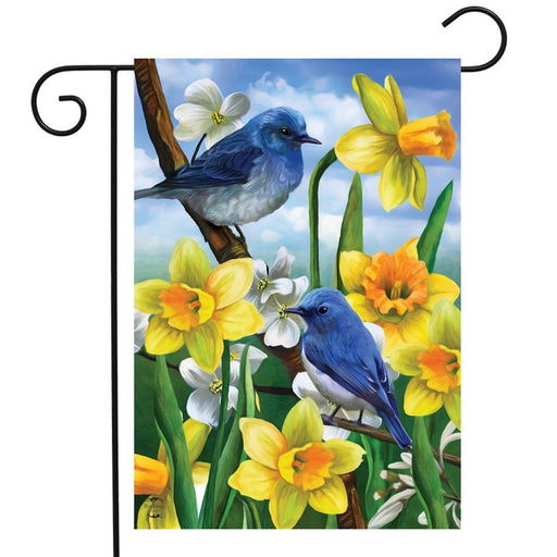 blue birds sitting on a tree with yellow daffodils flag