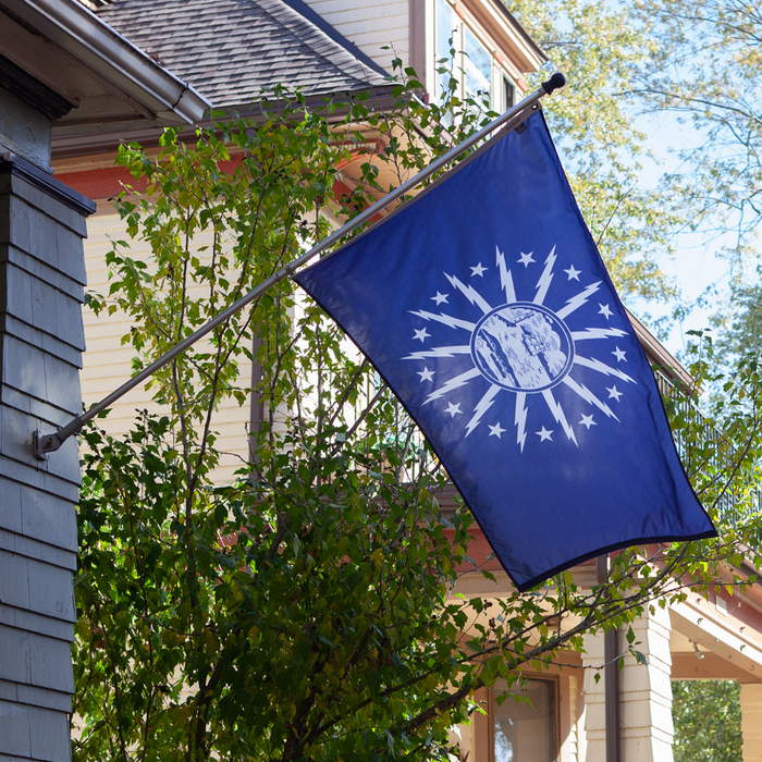 BLUE FLAG WITH A SHORE AND LIGHTHOUSE IN THE CENTER WITH LIGHTNING BOLTS AROUND THE CENTER OFF THE HOUSE
