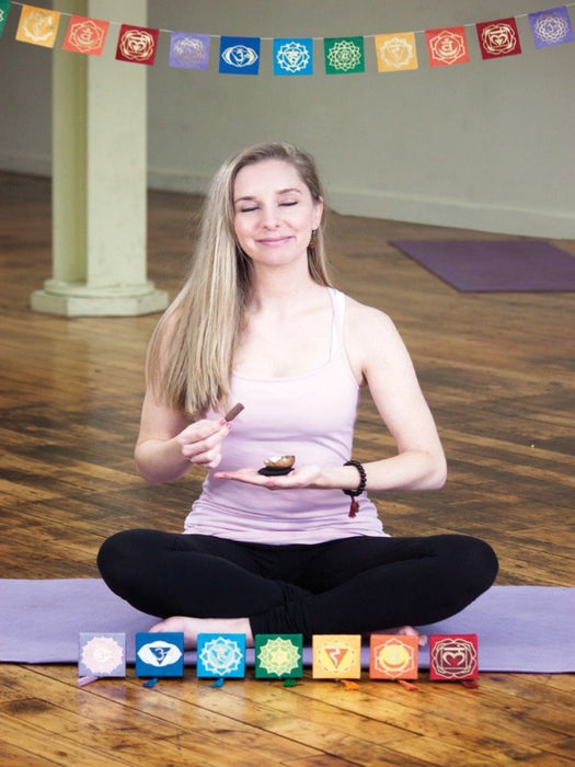 woman sitting on a yoga mat with the prayer flag set